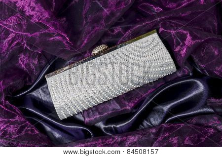 Clutch With Pearls On A Silk Background