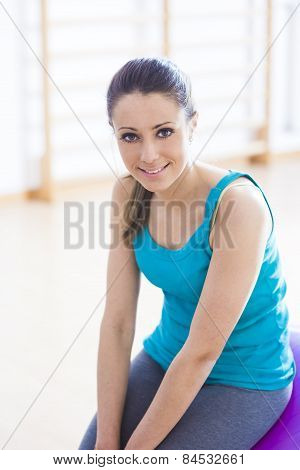 Smiling Woman Exercising At Gym With Fitness Ball