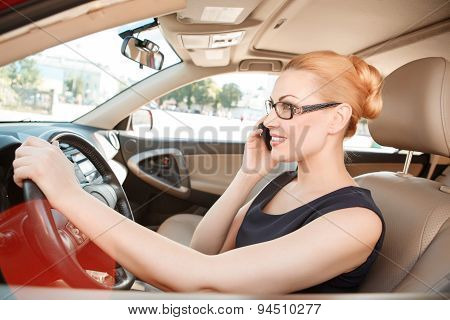 Businesswoman using mobile phone in car