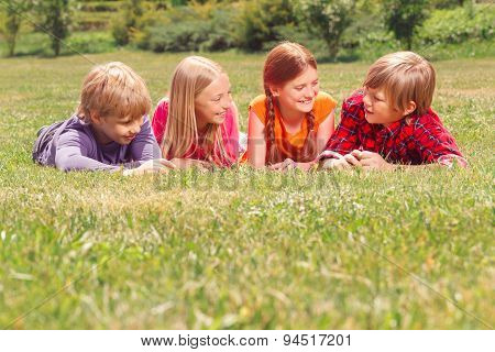 Upbeat children lying on grass in raw