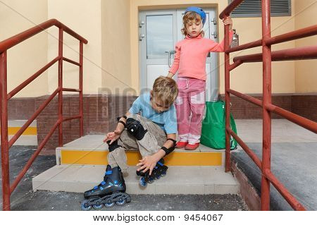 Kız ve erkek kardeşim ev adımlar. Paten dirsek ve diz kapakları çocuk.