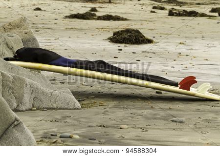 Surfboard Leaning On Rocks At Beach