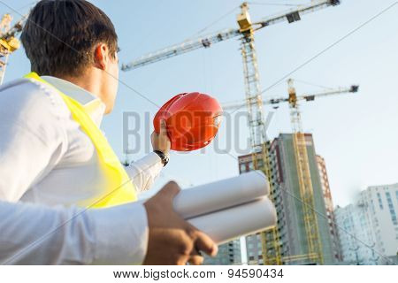 Closeup Of Engineer Posing On Building Site With Orange Hardhat