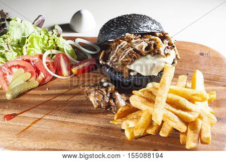 Beef black hamburger serve with salad and french fried