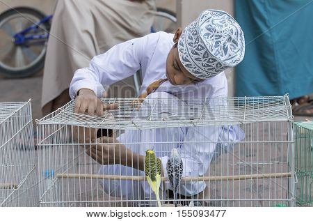 Omani Boy With A Bird Cage