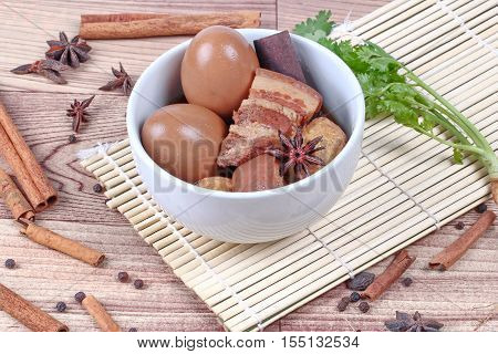 Thai Recipes : Stewed boiled egg with tofu and streaky pork ,call Khai Palo in Thai, take photo with herbs as Chinese star anise ,cinnamon,black pepper,cilantro roots and stems