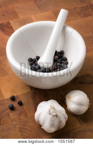 Juniper im Mörser und Pistill mit Knoblauch