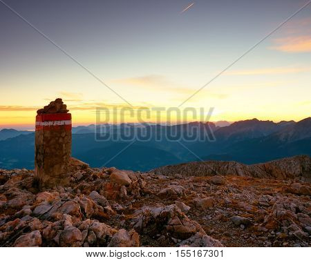 Border Stone On Apine Gravel  Cliff. Austria Germany Border. Daybreak Horizon