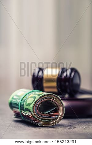 Judge's hammer gavel. Justice and euro money. Euro currency. Court gavel and rolled Euro banknotes. Representation of corruption and bribery in the judiciary.