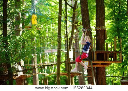 Adorable Little Girl Enjoying Her Time In Climbing Adventure Park