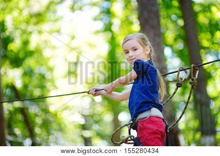 Adorable Little Girl Enjoying Her Time In Climbing Adventure Park