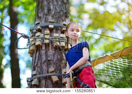 Adorable Little Girl Enjoying Her Time In Climbing Adventure Park