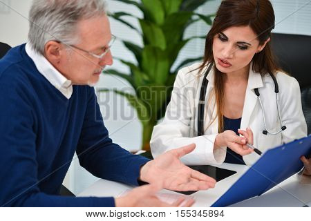 Doctor talking to his patient and showing documents. Focus on the doctor