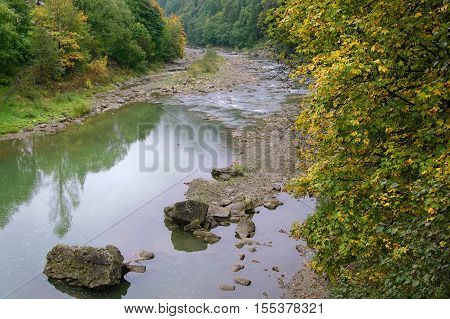 The bank of the Prut river in Carpathians at cloudy autumn day