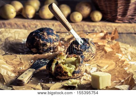 Jacket potatoes from campfire on old wooden table