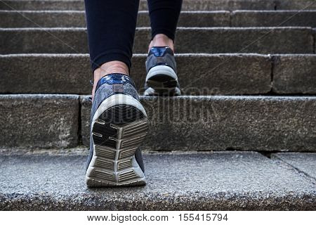Morning jogging young woman outdoors. Running up the stairs.