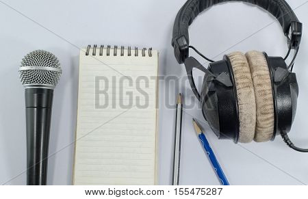 blank notebook in top view with music concept whitebackground headphones