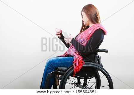 College university and job concept. Mobile technology. Young student worker woman with tablet ebook on wheelchair. Disabled person in real life.
