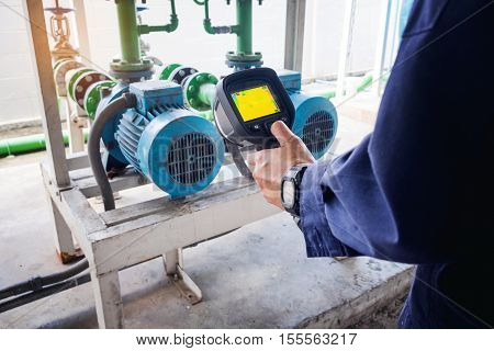 technician use thermal imaging camera to check temperature in factory