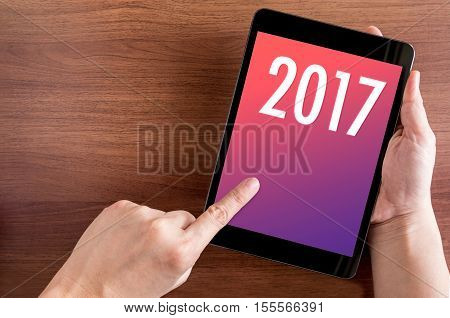 Hand Touch Tablet With 2017 Year Number On Screen On Wood Table,digital Happy New Year Card, Leave S