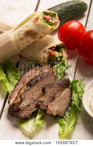 Doner kebab - fried beef meat with vegetables in tortilla