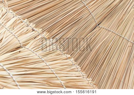 Straw beach umbrella close up. Woven straw background.