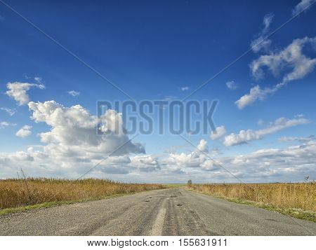 Yellow fields under a dramatic blue sky with white clouds nearby the ancient greek colony of Histria, on the shores of Black Sea. Histria is the oldest urban settlement on Romanian territory