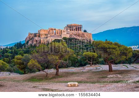 Parthenon and Herodium construction in Acropolis Hill in Athens, Greece. Beautiful landscape with green trees around ancient architecture.