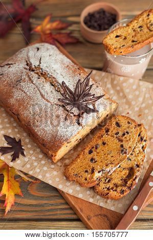 Homemade pumpkin cake with chocolate on wooden background. Autumn still life.