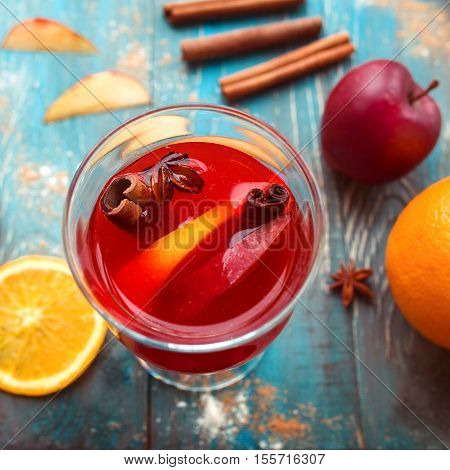 Orange, apple, cinnamom, anice, wine (mulled wine) on wooden background