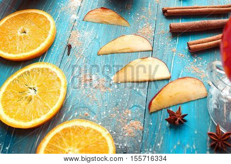 Orange, apple, cinnamom, anice, wine (mulled wine) on wooden background