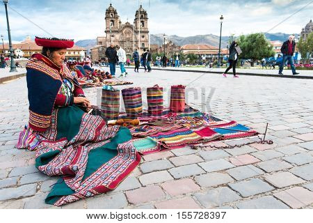  Peru Nov. 9 2015: Unidentified native weavers, dressed in traditional clothing, demonstrate their handicraft. Cusco.