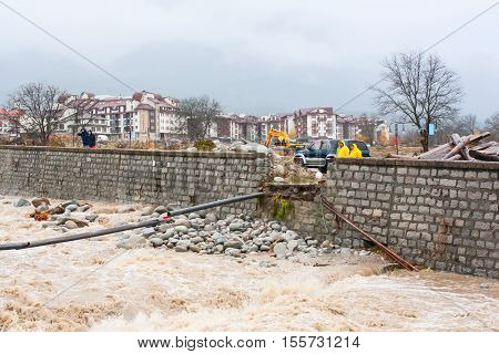 Bansko, Bulgaria - November 9, 2016: High water flow in Glazne river after heavy rains and remains of bridge carried away by the waters