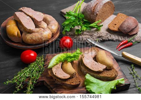 Sandwiches bread with homemade sausage. Loaf rye bread for sandwiches with homemade sausage. Assorted homemade sausage rings. Ingredients for sandwiches sausage thyme parsley peppers.