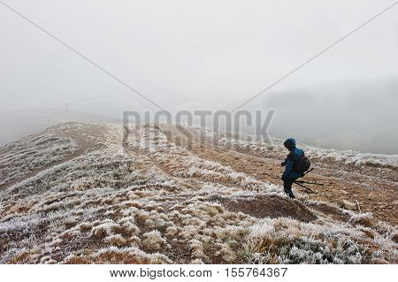 Tourist Photographer With Tripod On Hand Walking On Frozen Hill With Fog.