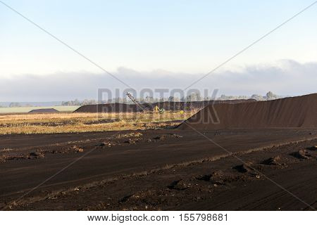 Bog And The Field On Which The Production Is Carried Out In Black Peat Mining, Industry, Old Tractor