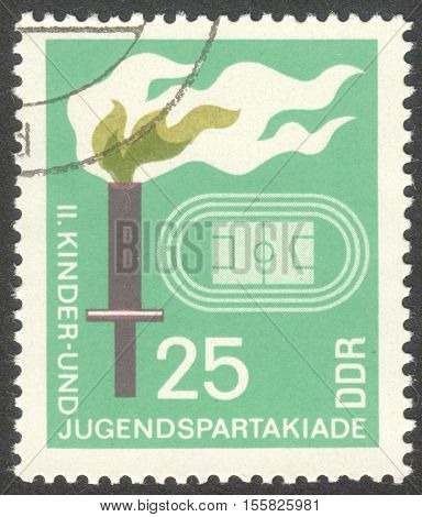 MOSCOW RUSSIA - CIRCA OCTOBER 2016: a post stamp printed in DDR shows a stadium and a torch the series "The 2nd Children’s and Youths’ Spartakiad Berlin" circa 1968