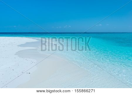 Tropical island in the Indian Ocean. White sand beach blue sky and a strip of ocean