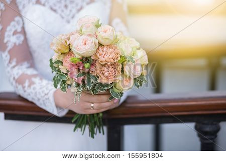 Wedding. Beautiful Weding Bouquet Of Different Flowers In The Hands Of The Bride In A White Wedding 