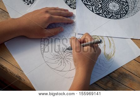 Hand of woman drawing yin yang for adult anti stress coloring book