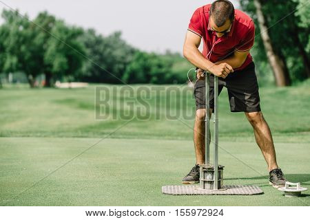Greenskeeper Cutting A Golf Hole, Preparing Course