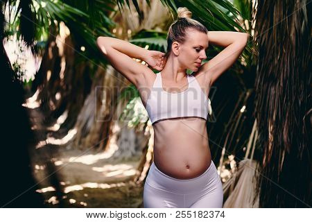 Young Attractive Blond Woman In White Sportswear Doing Yoga Pilates Fitness Exercises In Tropical Na