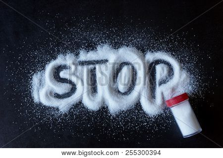 Salt Scattered On Black Surface. Drawn Word- Stop. Concept- Healthy Food, Diet, Harm To Health From 