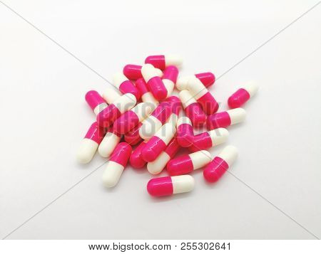 Medication And Healthcare Concept. Many White-pink Capsules Of Amoxicillin 250 Mg. Isolated On White