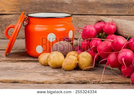 Enamelware Saucepan And Many Vegetables. Wooden Desk Surface Background.