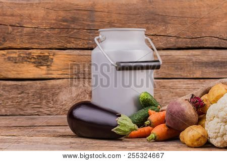 Enameled Milk Can With Handle And Raw Fresh Vegetables. Eggplant, Carrots, Beetroot, Potatoes And Ca