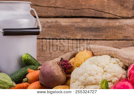 Gather Of Raw Vegetarian Food And Milk Can. Wooden Desk Background.