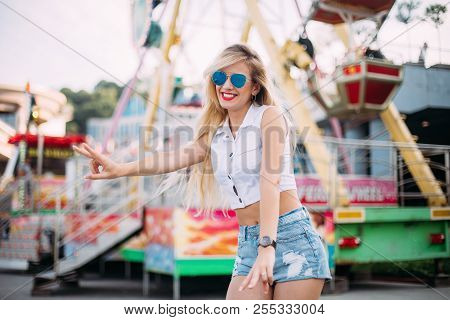 Stylish Happy Young Woman Wearing Short Denim Shorts And A White T-shirt. Brightred Lips . Portrait 