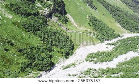 Top View Of A River In The Mountains On A Sunny Day. Top View Wild River Flowing Between Green Mount