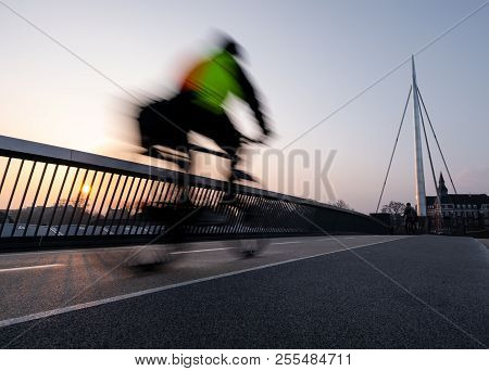 Cyclist On A Bicycle Bridge In Odense, Denmark.